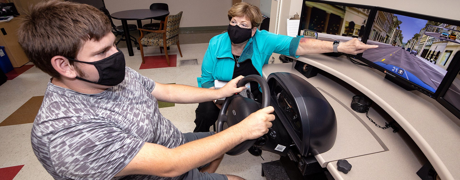 Dr. Anne Dickerson instructs Timmy Peaden in ECU’s driving simulator. 
(Photos by Rhett Butler | Video by Rich Klindworth)