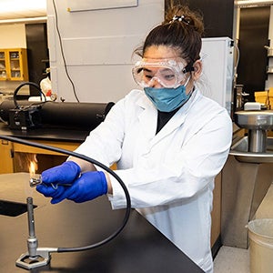 A student lights a Bunsen burner.