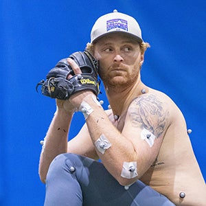 Former East Carolina University pitcher Evan Voliva throws a baseball while wearing reflective markers as part of doctoral candidate Christopher Curran’s research on pitching injuries and performance.