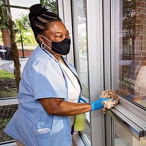 Brenda Hopkins wipes down a door in Gateway East Residence Hall. The housekeeping staff sanitized all residence halls before students arrived for the fall semester. 