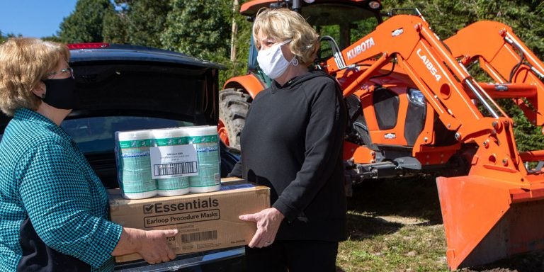 North Carolina Agromedicine Institute Director Robin Tutor Marcom, left, shares protective masks and disinfectant wipes with Tracey Taylor, owner of Stone Mountain Farms in Vilas. The institute was recognized by the Engagement Scholarship Consortium for an exemplary project for working across the state to provide health care and safety training to farmers, foresters, fishermen, and their families and communities. (Photo by Marie Freeman, Appalachian State University)