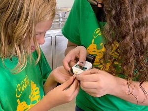 A camper gets assistance checking blood sugar 