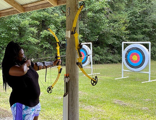 A camper takes aim during an archery lesson