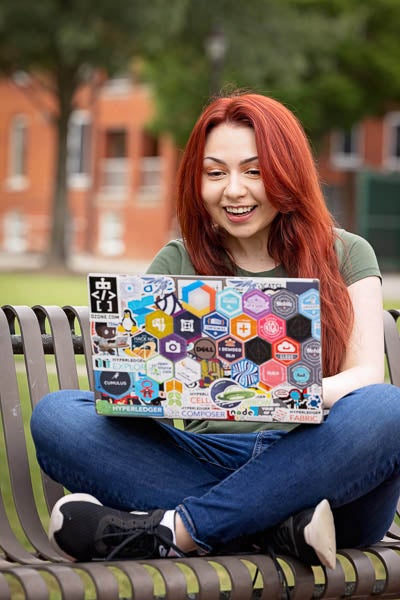 ECU student Amelia Hernandez sits with her laptop on the mall.