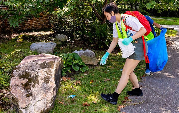 Malaya Zerbe picks up trash on Harding Street during the Day of Service. (Photo by Cliff Hollis)