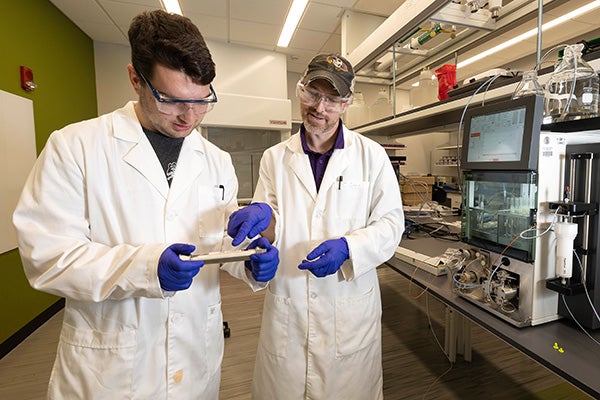 Justin Tanhauser, a junior bioprocess engineering major from Wake Forest, and lab supervisor Chris Cone look at readings in a lab in the new Life Sciences and Biotechnology Building.