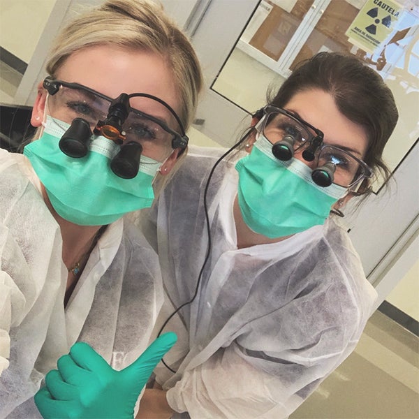 Rachel Cantrell and classmate Ashley Huff Collins gives a thumbs up in a clinic office.