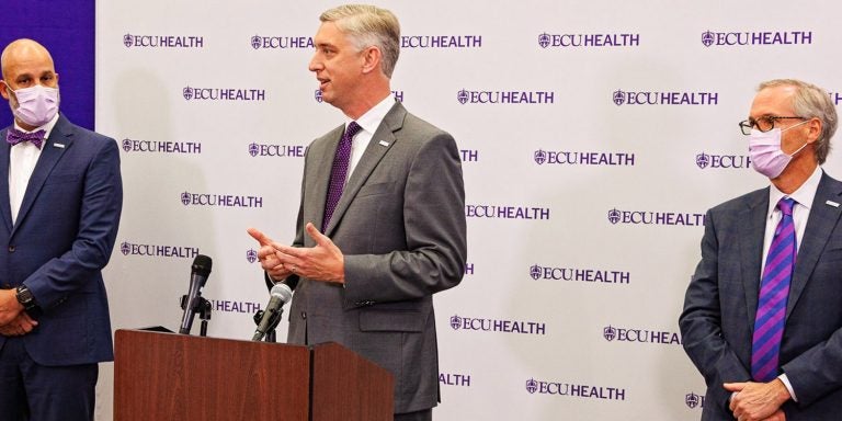 ECU Chancellor Philip Rogers and Dr. Michael Waldrum, CEO of Vidant Health, announce the new logo on April 14 for the ECU Health system.