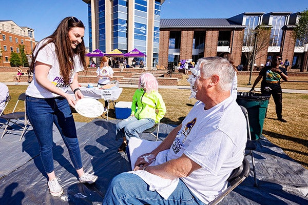 An ECU student pays to pie a person in the face during Pirates Vs. Cancer.