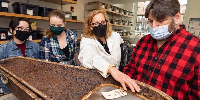 Dr. Megan Perry talks about a coffin, recovered from the Rhem family ancestral tomb in New Bern’s Cedar Grove cemetery, with family member Michael Miller, right, and anthropology graduate students Bridget Cone and Ceara Nicholson.