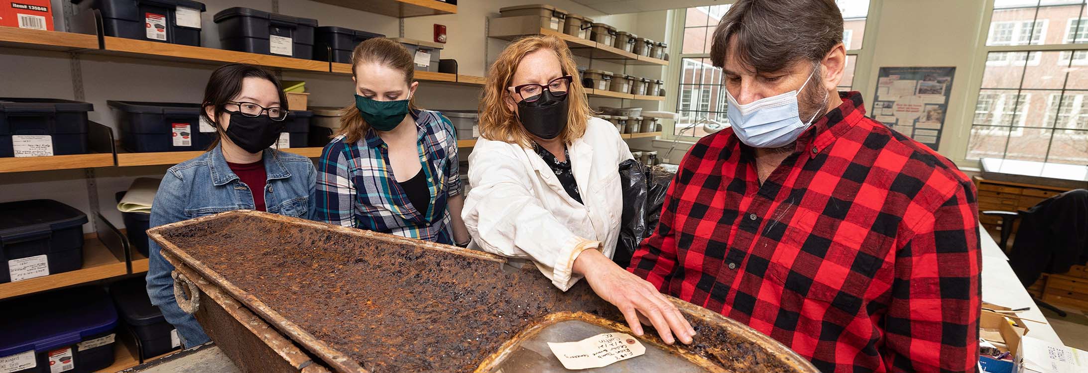 Dr. Megan Perry talks about a coffin, recovered from the Rhem family ancestral tomb in New Bern’s Cedar Grove cemetery, with family member Michael Miller, right, and anthropology graduate students Bridget Cone and Ceara Nicholson.