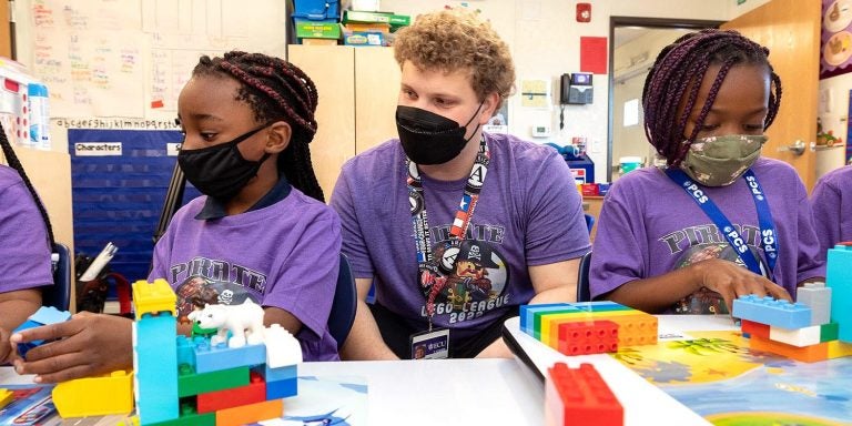 J.H. Rose High School senior Carter Lamson works with students at the ECU Community School on a LEGO League program.