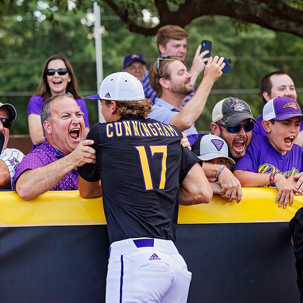 East Carolina baseball player Carter Cunningham celebrates with fans in The Jungle at Clark-LeClair Stadium.