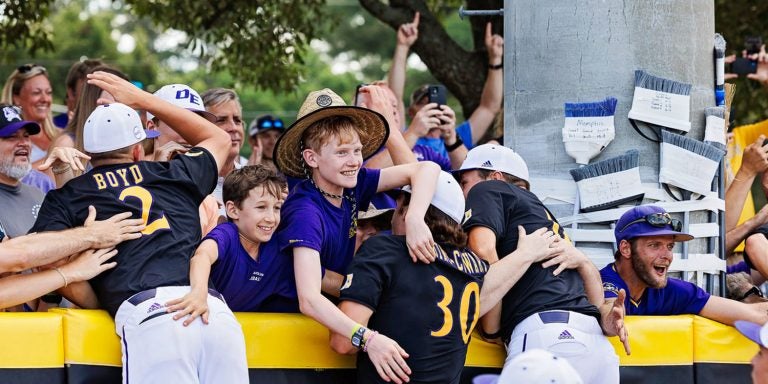 East Carolina baseball players celebrate with fans in The Jungle after winning the NCAA Greenville Regional championship.