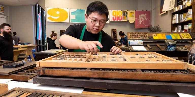 East Carolina University student Frank Liu works on a project in an experimental letterpress print class.