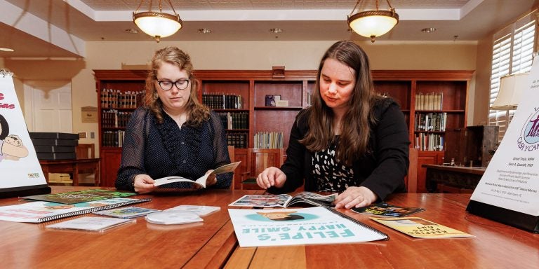 Laupus Library's Jamie Bloss and Layne Carpenter look over donated items designed for migrant farmworkers.