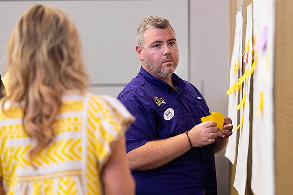 Steven Trotter places a sticky note during a resilient campus summit activity at the Main Campus Student Center.