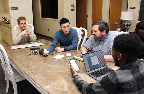 From left, Dr. Kamran Sartipi, assistant professor in the Department of Computer Science, Dr. Young Joo Kim, associate professor in the Department of Occupational Therapy, Dr. Ricky Castles, associate professor in the Department of Engineering, and computer science student Braxton Chambers check smart devices that are designed to support the health care of older adults in a Department of Occupational Therapy apartment lab in the Health Sciences Building.