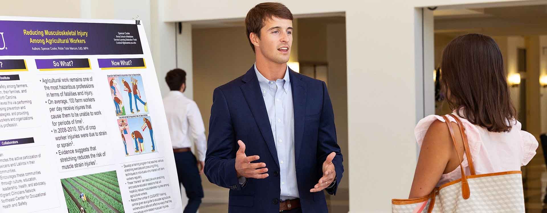 Spencer Cooke discusses his project during a poster presentation.