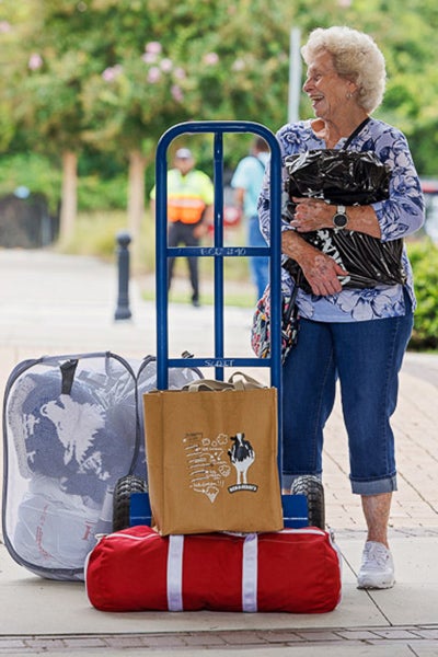 Sharon Justice stands by a cart as she helps her grandson, Ben Justice, move into Ballard Hall. 