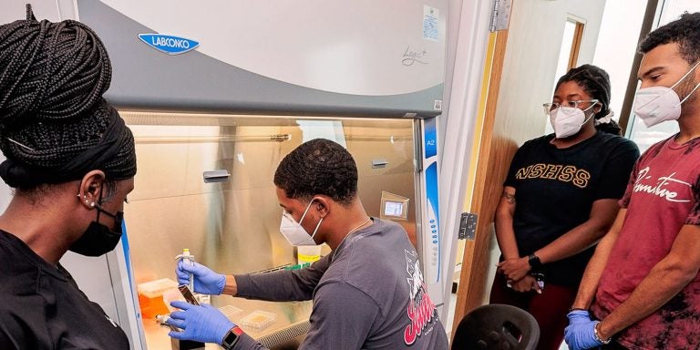 Markis’ Hamilton, an undergraduate student from Fayetteville State University, works in a hood in the East Carolina University Life Sciences and Biotechnology Building.