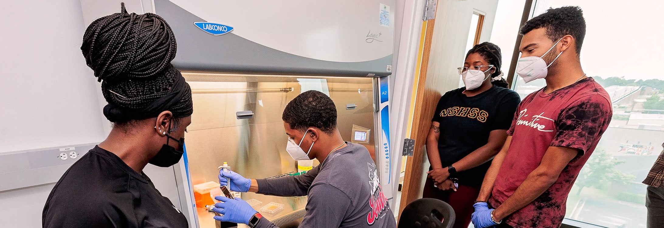 Markis’ Hamilton, an undergraduate student from Fayetteville State University, works in a hood in the East Carolina University Life Sciences and Biotechnology Building.