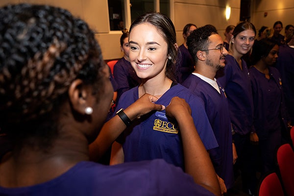 East Carolina University nursing students pin their peers with Lamp of Learning pins during a ceremony Sept. 8.