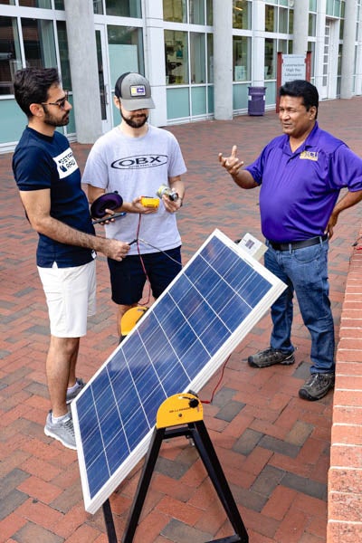 Dr. Ranjeet Agarwala, right, associate professor in the Department of Technology Systems, works with students Behzad Zeinolabedini, left, and Randy Weddle during a solar power demonstration as part of Pollution Prevention Week outside the Science and Technology Building.