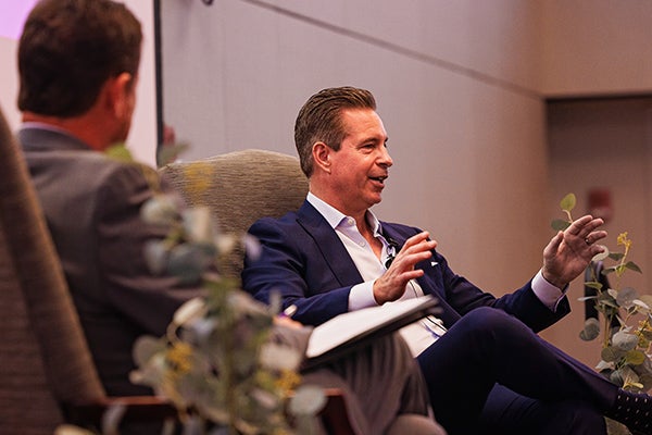 East Carolina University College of Business alumnus John May participates in a fireside chat with COB Interim Dean Mike Harris at the college's annual business leadership conference.