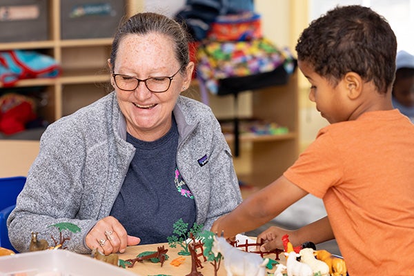 Teaching assistant Susan Mendell works with a student at Care-O-World Early Learning Center in Winterville.