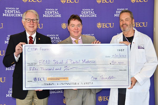 East Carolina University School of Dental Medicine Dean Dr. Greg Chadwick, from left, the CITA Foundation’s Dr. Kevin Collins and Dr. Ed Connelly, associate dean for clinical affairs, display a donation check from the foundation.