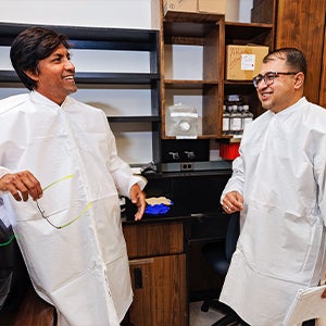 Lok Pokhrel, left, and Shaw Akula work in a lab in the Brody School of Medicine at East Carolina University. 