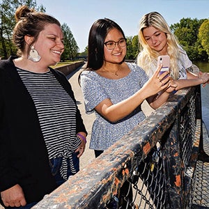 Emily Yeager spends time her with student researchers Anjalee Hou, center, and Taylor Cash. Hou and Cash run social media accounts promoting Yeager’s research into the Blue Economy Corridor. 
