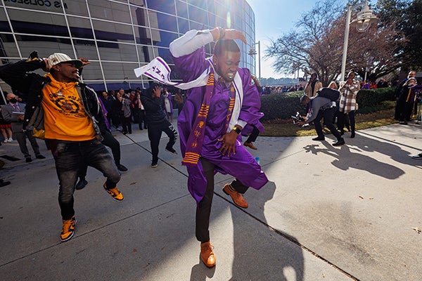 An ECU graduate dances outside to celebrate commencement after the ceremony.