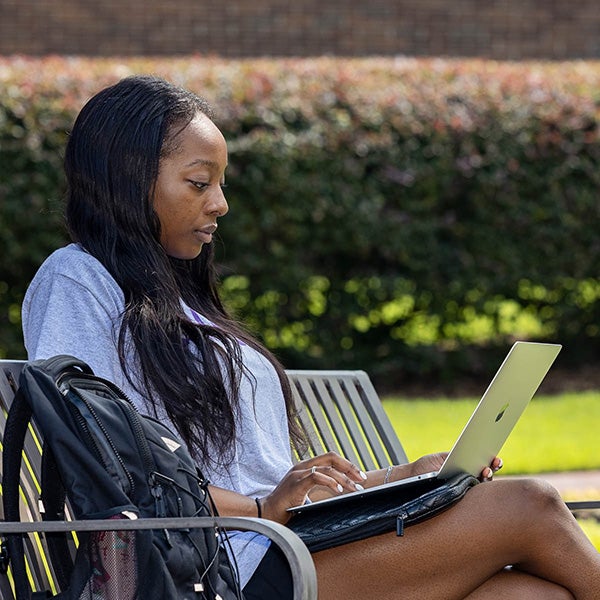 A student works on her laptop on campus. ECU’s online master’s degree programs in business, criminal justice, education and nursing rank among best in the nation. 