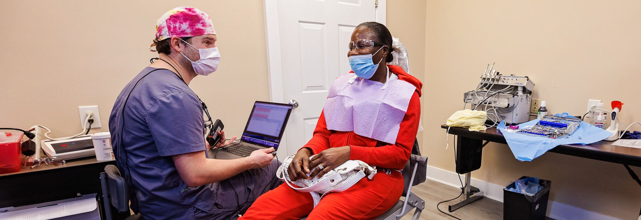 East Carolina University School of Dental Medicine resident Charles Haddock explains a procedure to patient Santana McCoy at the school’s clinic in Hyde County. (Photo by Cliff Hollis)