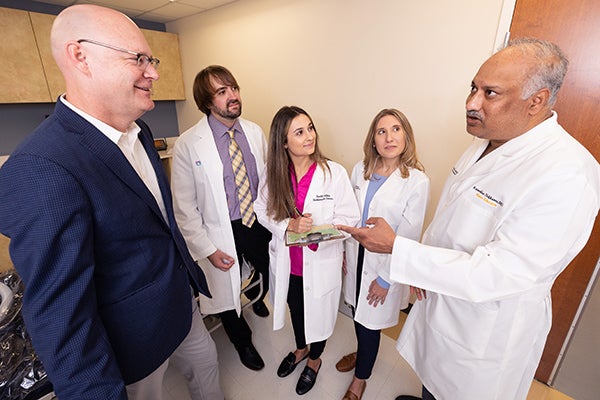 Sam Sears, left, director of ECU’s clinical health psychology program, discusses the field of cardiac psychology with doctoral students Zachary Force, Scarlett Anthony and Elizabeth Jordan, as well as Raj Nekkanti, right, director of ECU’s cardiac fellowship program