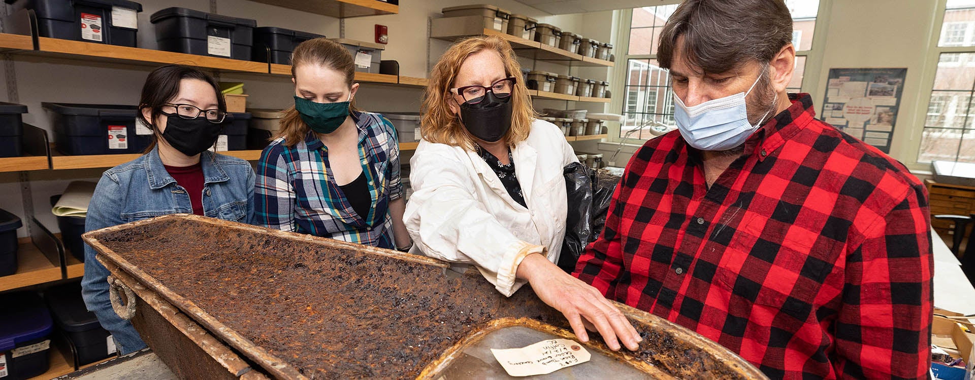 Perry discusses a coffin recovered from the recovered from the Rhem family ancestral tomb in New Bern’s Cedar Grove cemetery, with family member Michael Miller, right, and anthropology graduate students Bridget Cone and Ceara Nicholson. 