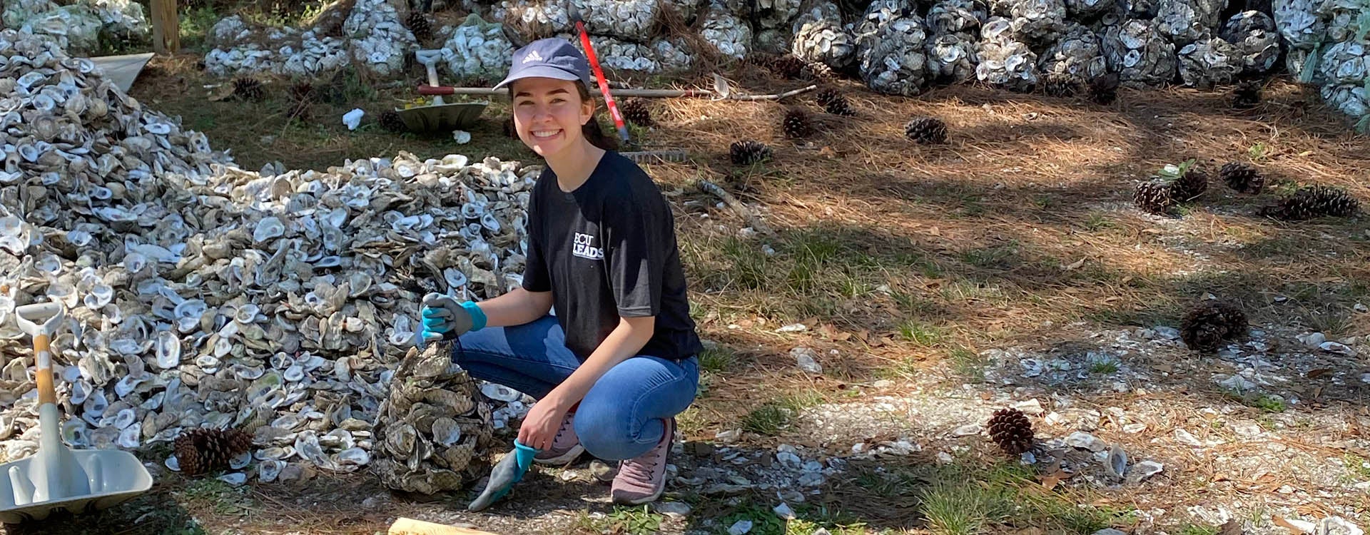 ECU student Sarah Elliott helps bag oyster shells to build a living shoreline in Carteret County.