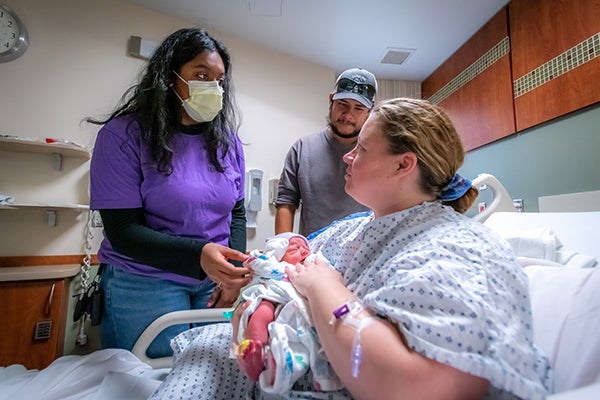ECU student birthing companion volunteer Rachana Charla shares a moment with Sierra Chavez following the birth of her child at ECU Health Medical Center.