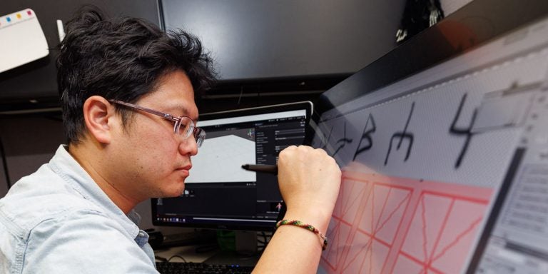 Kuan-Hung Chen, an IT consultant with the East Carolina University College of Nursing, works on graphic elements of a virtual reality game used to teach students. (ECU photos by Cliff Hollis)
