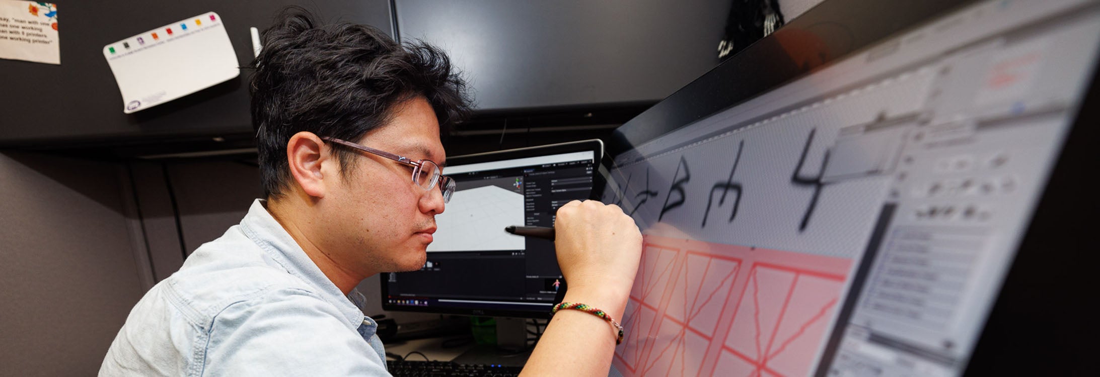Kuan-Hung Chen, an IT consultant with the East Carolina University College of Nursing, works on graphic elements of a virtual reality game used to teach students. (ECU photos by Cliff Hollis)