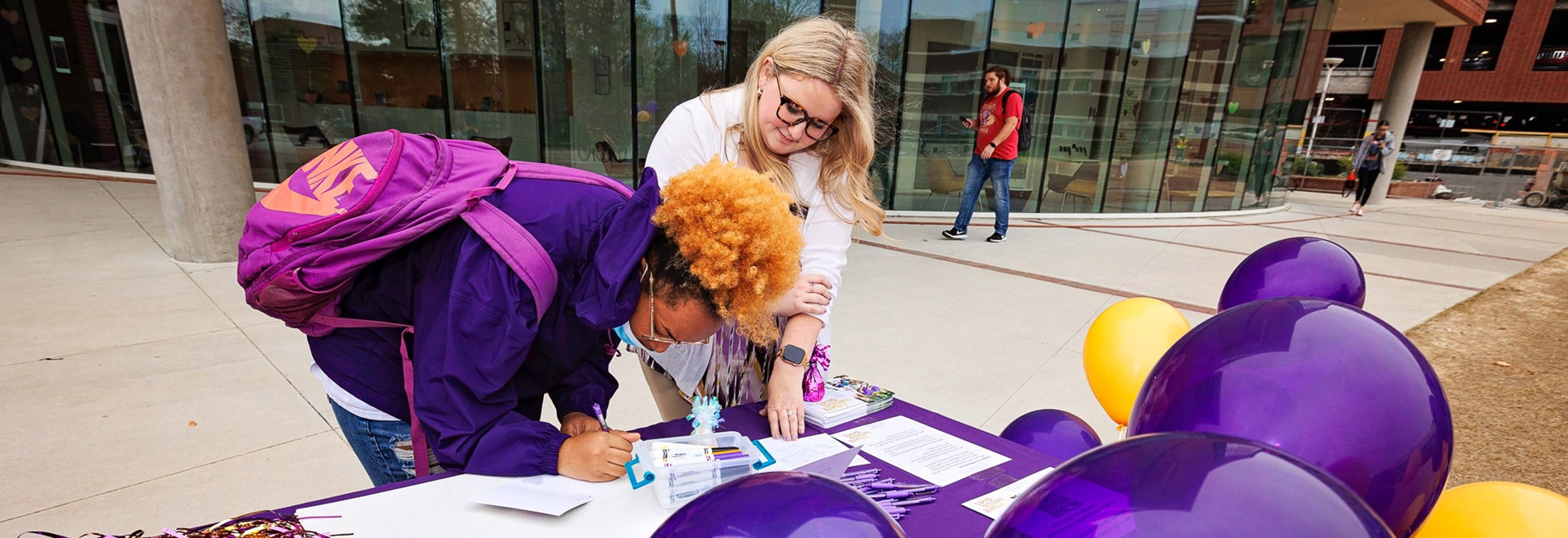 East Carolina University College of Health and Human Performance Director of Outreach Mack Craven, right, helps a student write a thank you letter to a gift donor during last year's Pirate Nation Gives. The annual day of giving returns for the seventh year this Wednesday.