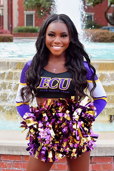 East Carolina University senior Reyna Crooms found her group of Pirates with the ECU Club Dance Team. Crooms stands in front of the ECU fountain her in dance uniform.