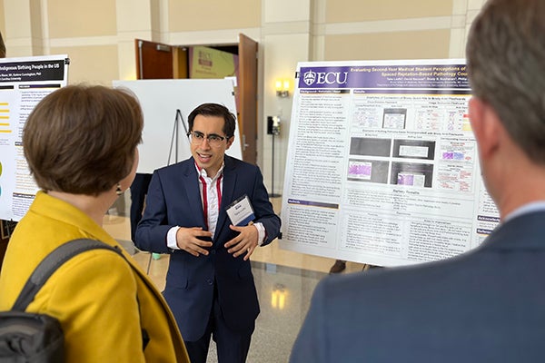 Second-year Brody School of Medicine student Taha Lodhi discusses his poster presentation during Medical Education Day on April 4.