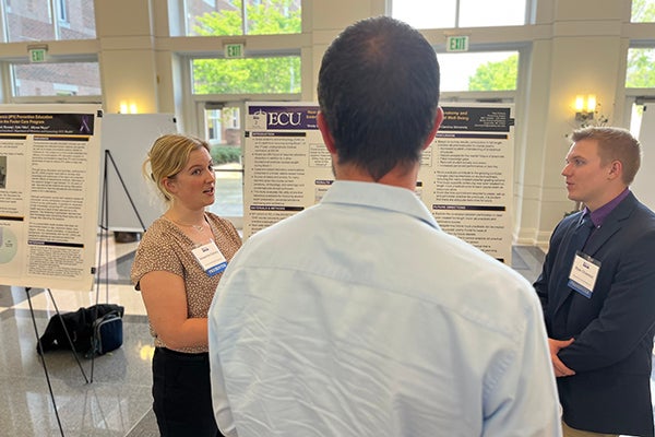 Alexandra Doherty, M3 student, and K. Ryan Dickerson, M2 student at the Brody School of Medicine, discuss their poster presentation. 
