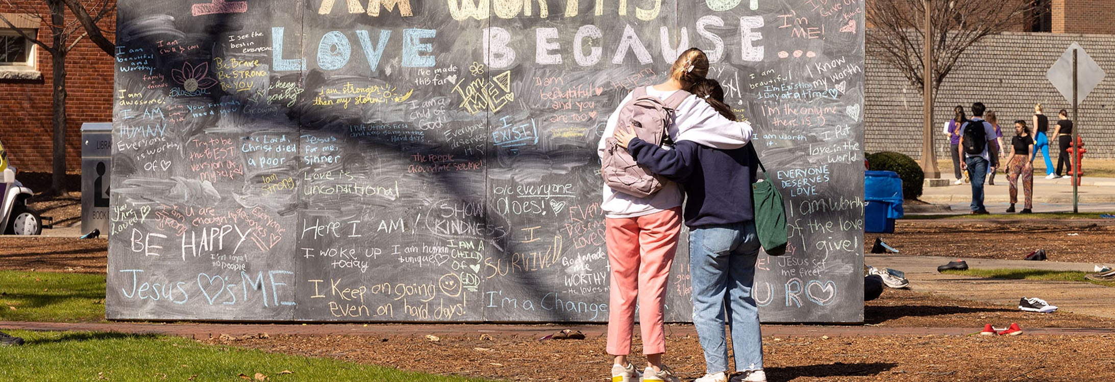 East Carolina University students look at a chalkboard of messages during a mental health awareness event in February.