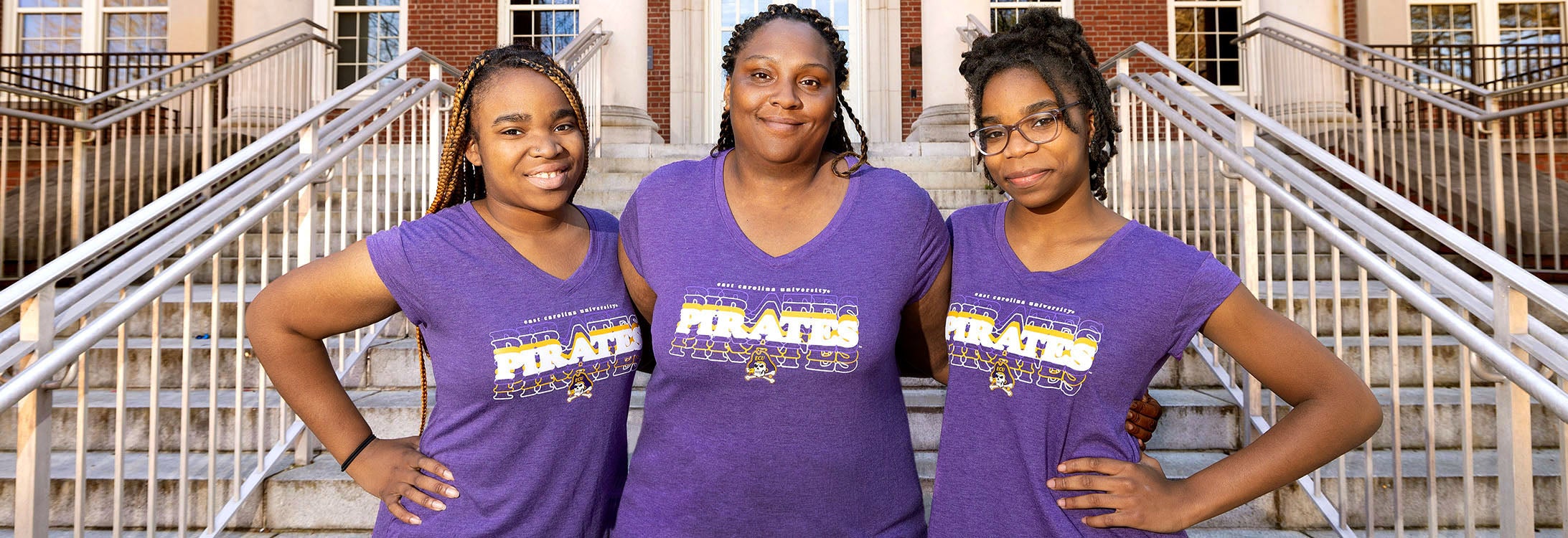 Tanisha Grimes, middle, a housekeeping supervisor at ECU, stands with two of her six children on ECU’s campus. Ashawndrea, left, is a rising senior in the clinical laboratory science program and Ashari attends Innovation Early College High School at ECU.