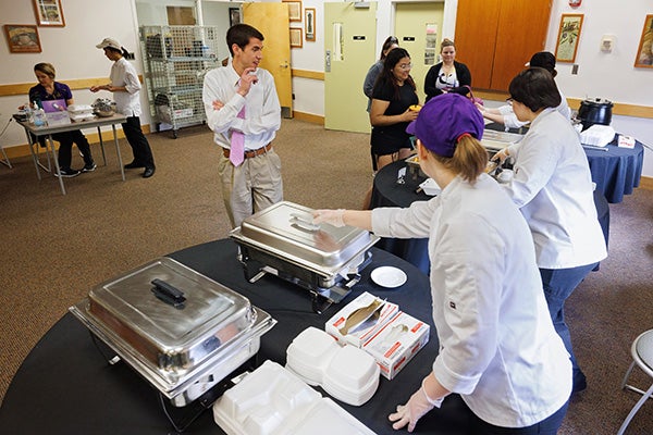 Nutrition sciences students serve food at the Rivers building.