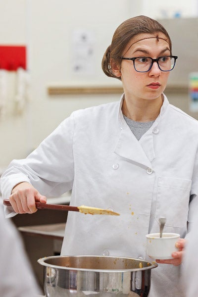 Nutrition sciences student Morgan Fletcher prepares food during a Quantity Foods Lab at the Rivers Building.